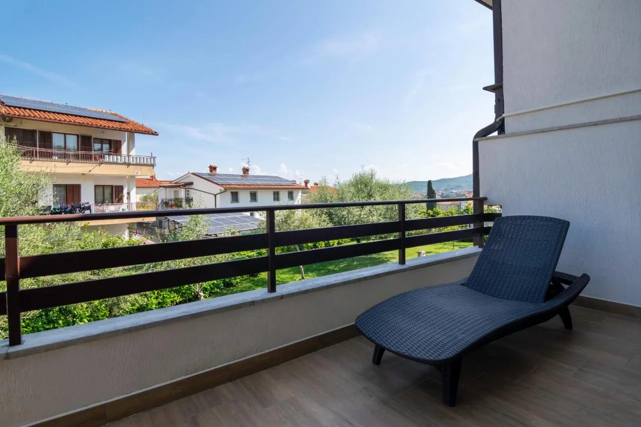 Balkon z ležalnikom in pogledom čez vrt