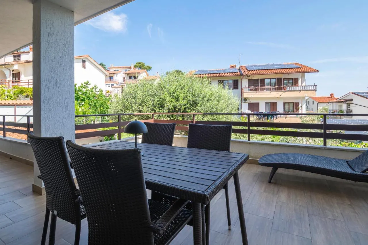 Pokrit balkon z mizo in ležalnikom nad vrtom
